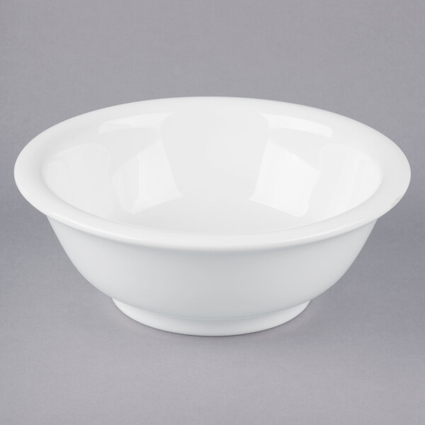A Tuxton white china footed salad bowl on a gray surface.