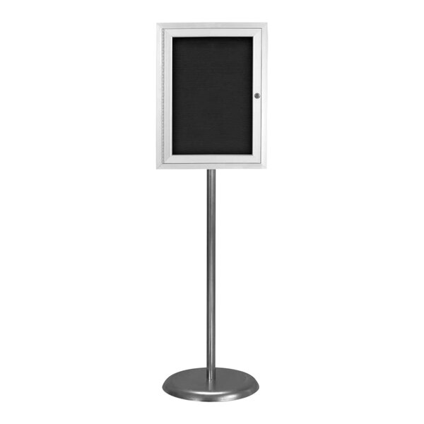 A white sign with black letters on a metal pedestal stand.