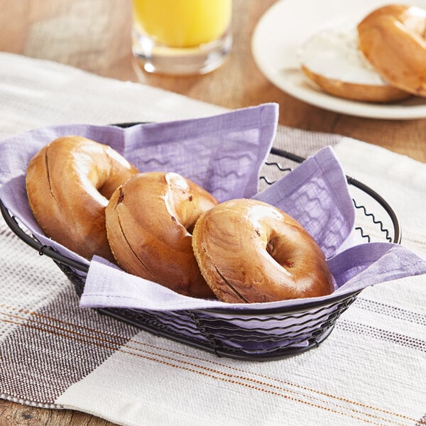 A basket of Original Bagel Cinnamon Raisin Mini Bagels on a table.