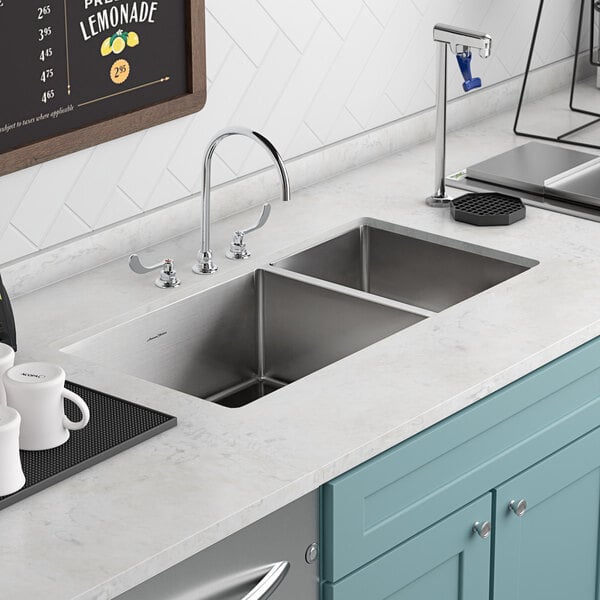 An American Standard stainless steel undermount sink with two compartments in a kitchen counter.