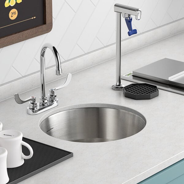 An American Standard stainless steel undermount sink with one compartment on a counter with white mugs.