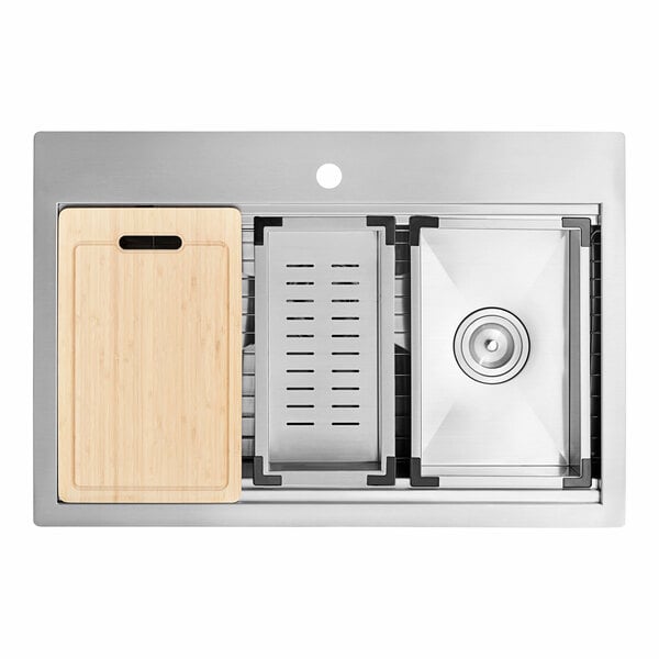 A white stainless steel American Standard Chive workstation sink with a wooden cutting board over the basin.
