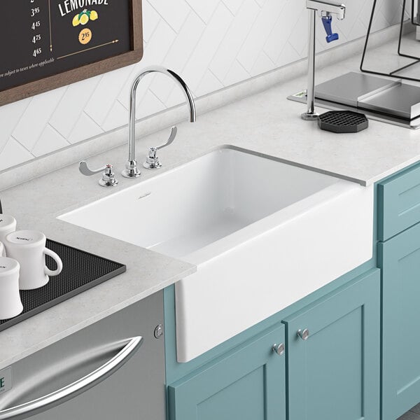 An American Standard white cast iron sink with a faucet above it.