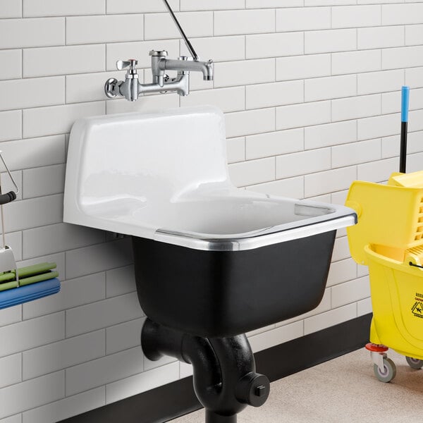 An American Standard enameled cast iron wall-mount service sink in white with a mop and bucket.