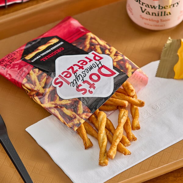 A bag of Dot's Homestyle Pretzels Original Seasoned Pretzel Twists with some pretzels spilling onto a napkin.