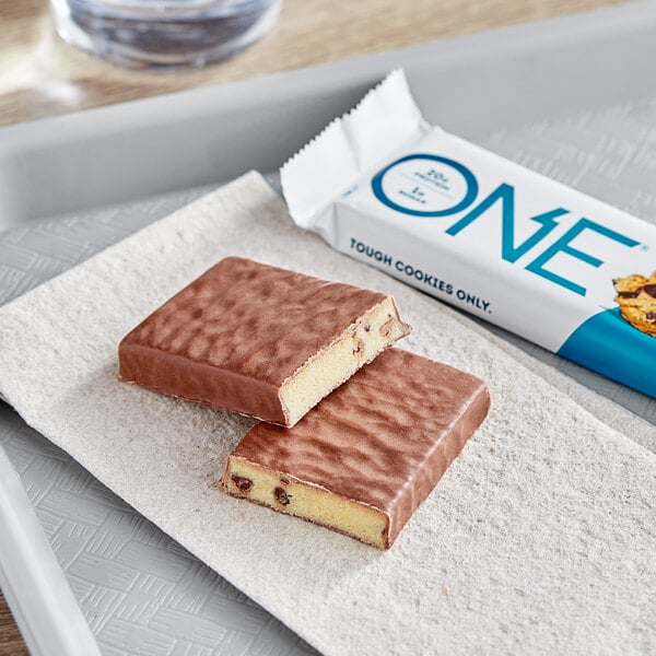 A rectangular brown and white ONE Chocolate Chip Cookie Dough Protein Bar on a tray.