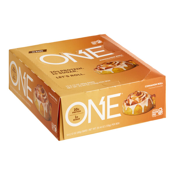 The box of ONE Cinnamon Roll Protein Bars with one bar in the foreground.