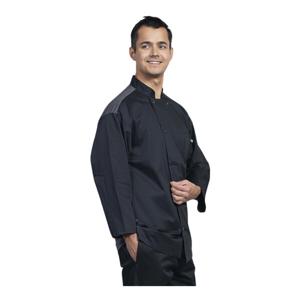 A man wearing a black Uncommon Chef coat with silver mesh and 3/4 sleeves.