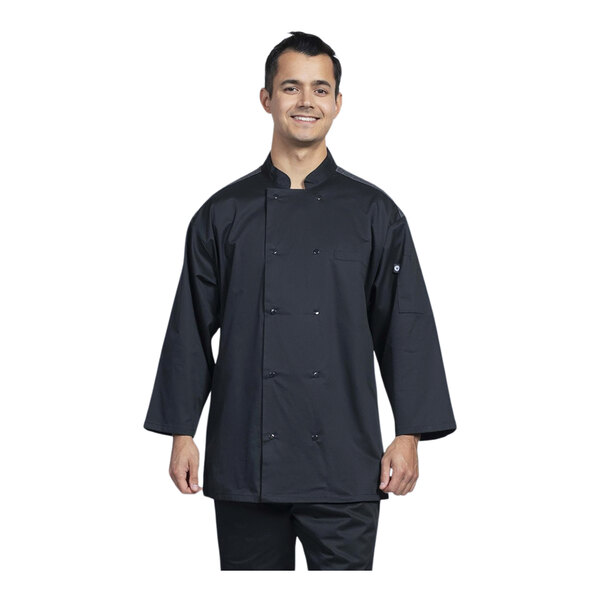 A man wearing a Uncommon Chef black chef coat with silver mesh back and 3/4 sleeves is smiling.