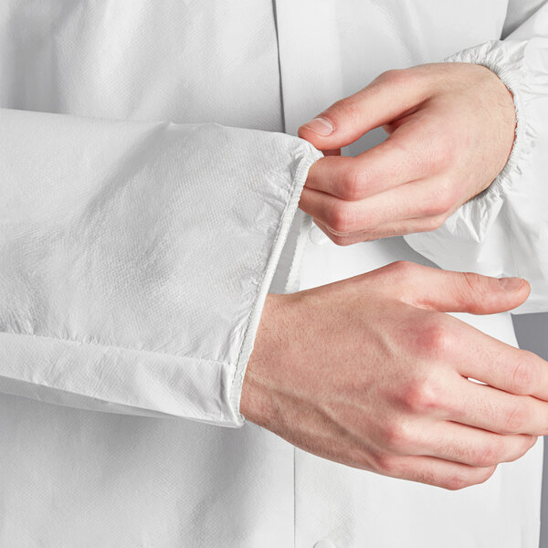 A person wearing Lavex white microporous coveralls with attached boots and hood.