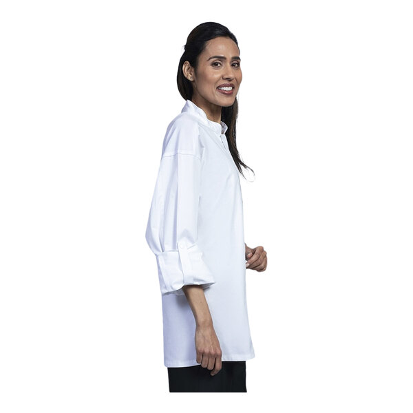 A woman wearing a Uncommon Chef white long sleeve chef coat with white mesh on the back.