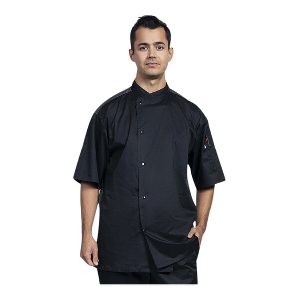 A man wearing a Uncommon Chef black chef coat with silver mesh.