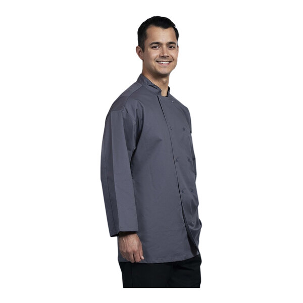 A man wearing a slate Uncommon Chef Treviso chef coat with long sleeves and a mesh back.