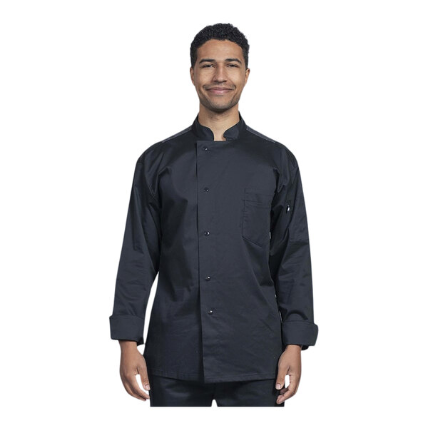 A man wearing a black Uncommon Chef long sleeve chef coat with silver mesh on the back and a customizable silver name tag.