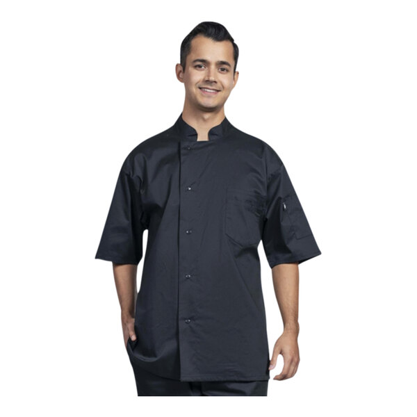 A man wearing a black Uncommon Chef short sleeve chef coat with black mesh back smiling.