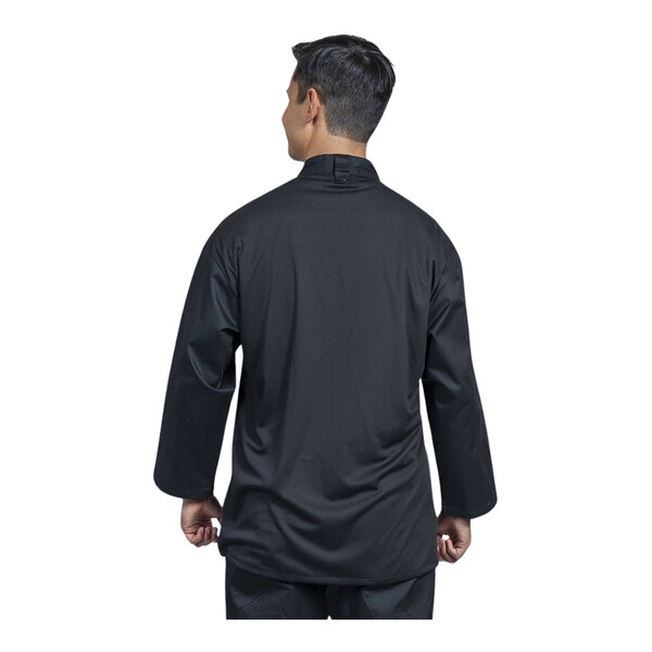 A man wearing a Uncommon Chef black chef coat with black mesh back.