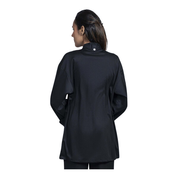 A woman wearing a Uncommon Chef black long sleeve chef coat with black mesh back.