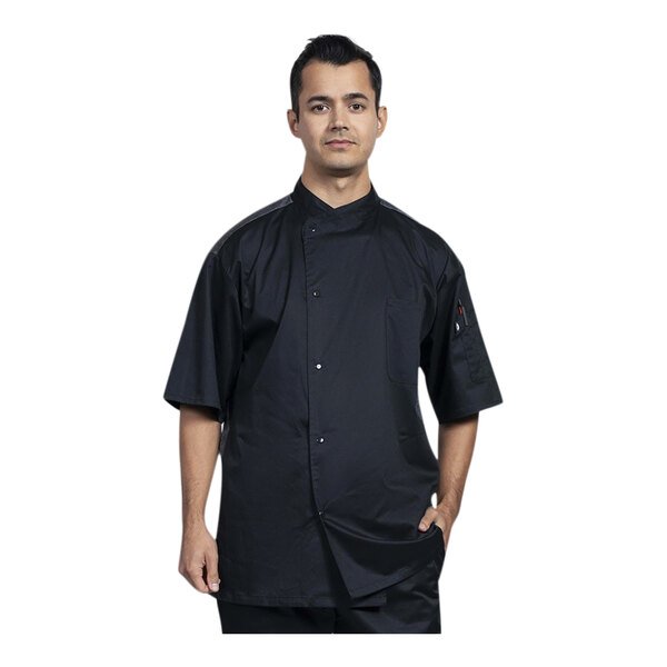 A man wearing a black Uncommon Chef Modena short sleeve chef coat with a silver mesh back.