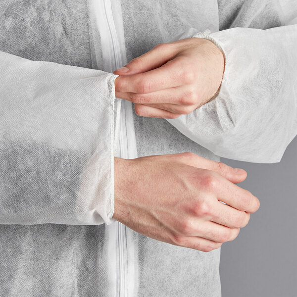 A person wearing white Lavex coveralls with elastic wrists and ankles.