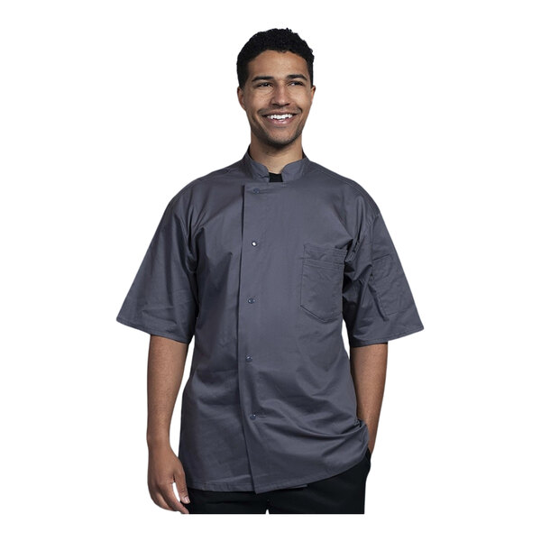 A man wearing a Uncommon Chef Venice short sleeve chef coat with a mesh back smiling.