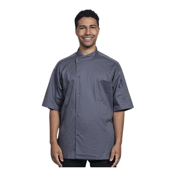 A man wearing a Uncommon Chef Modena slate short sleeve chef coat with gray mesh back.