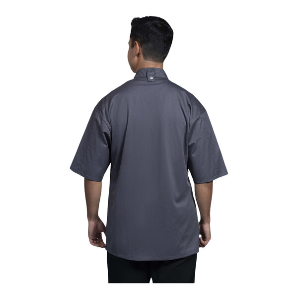 A man wearing a Uncommon Chef slate grey short sleeve chef coat with a slate mesh back.