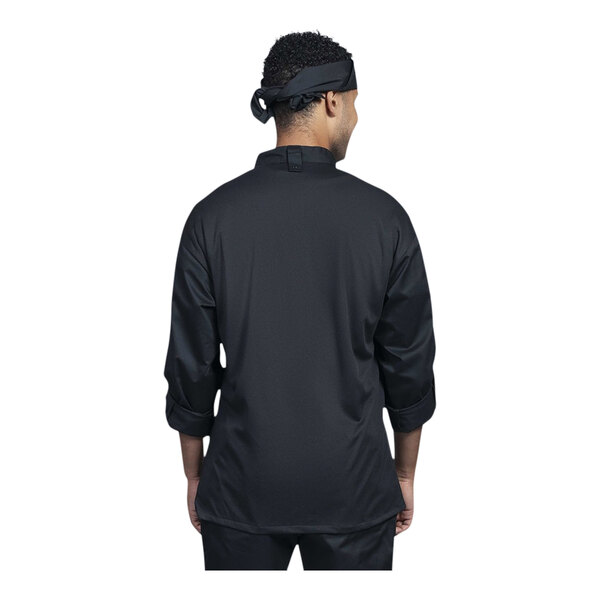 A man wearing a Uncommon Chef black long sleeve chef coat with black mesh back.