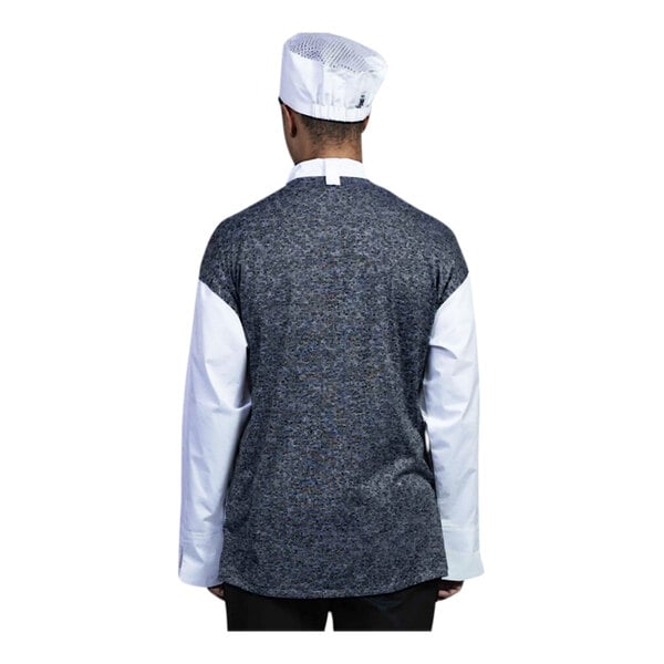 A person wearing a white Uncommon Chef Capri chef coat and hat with a grey mesh back.