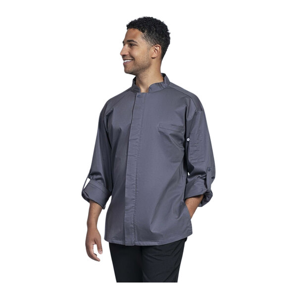 A man wearing a Uncommon Chef Pescara long sleeve chef coat with a grey shirt underneath.