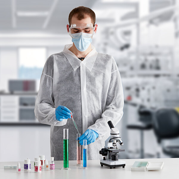 A man wearing a Lavex white lab coat and gloves holding a test tube.