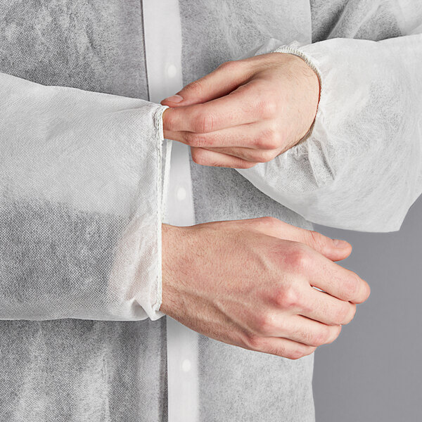 A person wearing a white Lavex lab coat with elastic wrists and gloves.