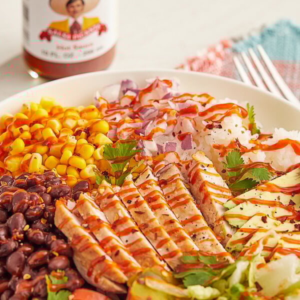 A plate of food with Tapatio hot sauce on a table.
