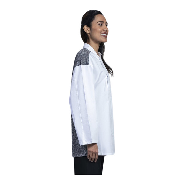 A woman wearing a Uncommon Chef white 3/4 sleeve chef coat with black accents.