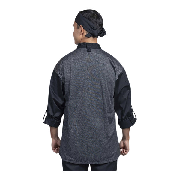 A man wearing a Uncommon Chef black chef coat with a silver and grey mesh back.