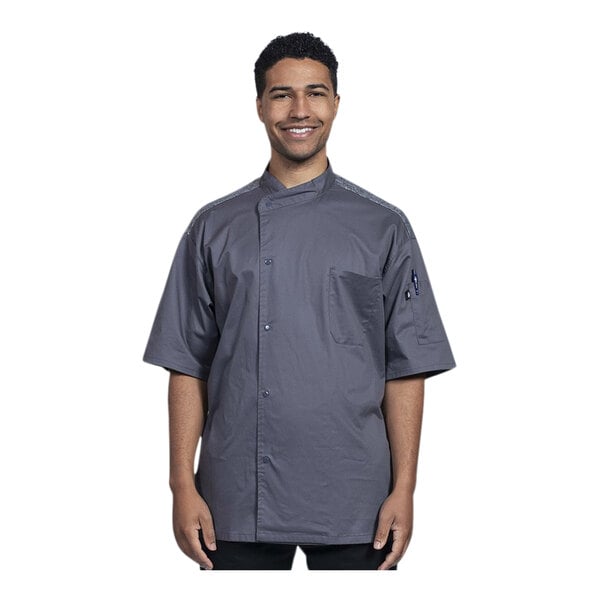 A man wearing an Uncommon Chef short sleeve chef coat with a gray mesh back.