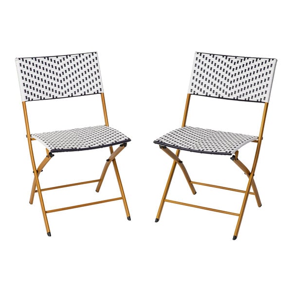 A pair of navy and white synthetic rattan folding chairs with natural steel frames.