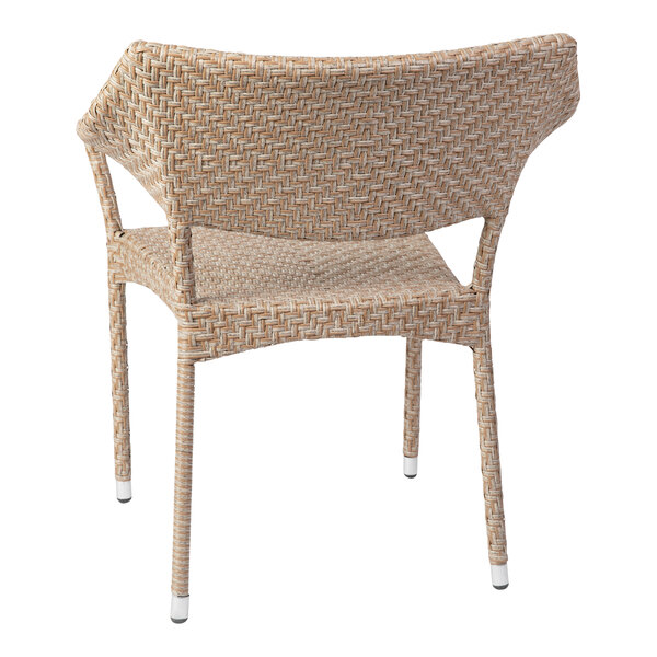 A close-up of a Flash Furniture Jace Natural Synthetic Rattan Stackable Arm Chair with a white back and seat.