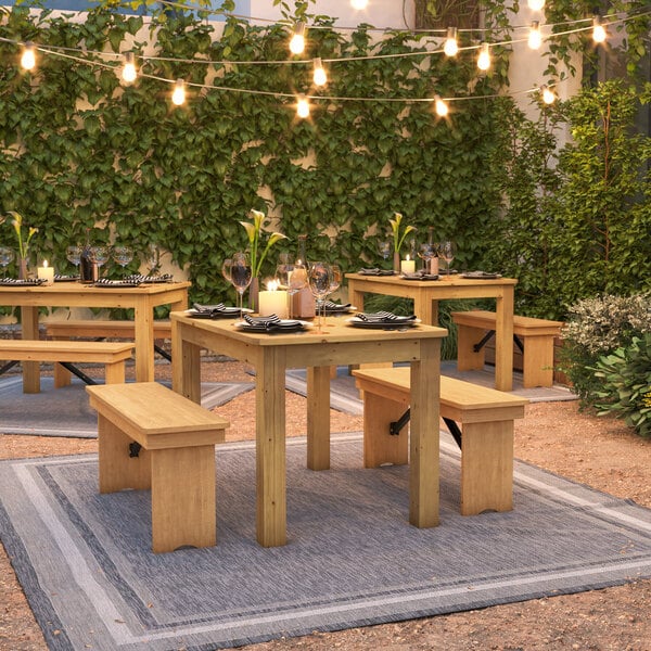 A wooden Flash Furniture rectangular table with benches on a patio.