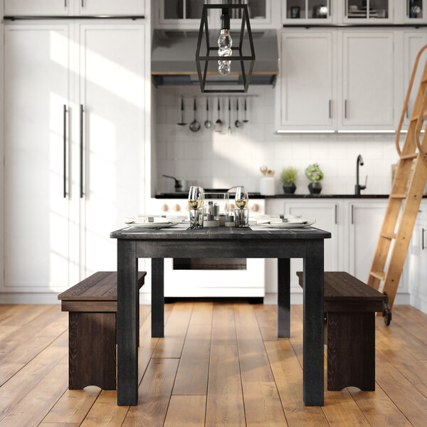A Flash Furniture rectangular pine wood table with a black wash finish set for dining in a home kitchen.