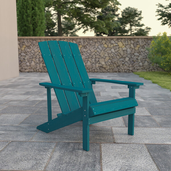 A seafoam blue Charlestown Adirondack chair on a stone patio.