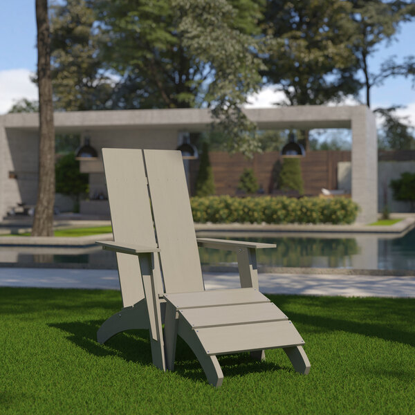 A Flash Furniture gray faux wood Adirondack chair on the grass.