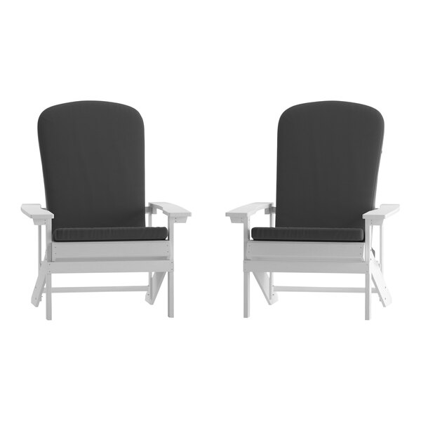 Two white Adirondack chairs with gray cushions.