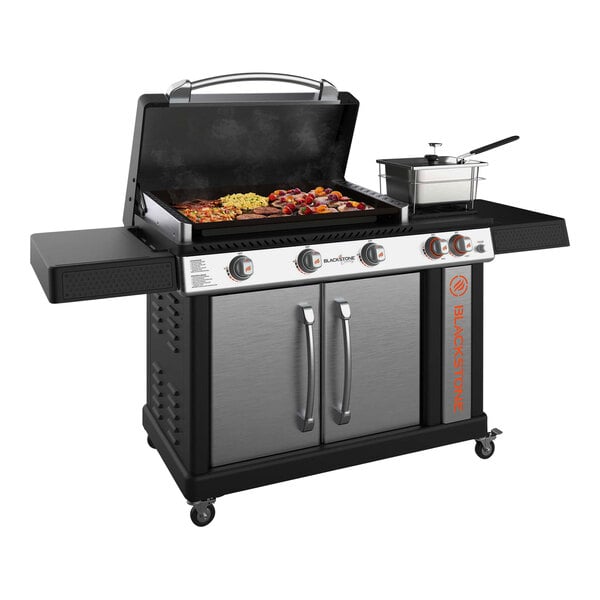 A Black and silver Blackstone outdoor griddle with a pan on it.