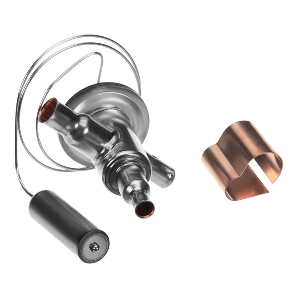 A close-up of a Manitowoc Ice expansion valve kit metal part with copper pipes.