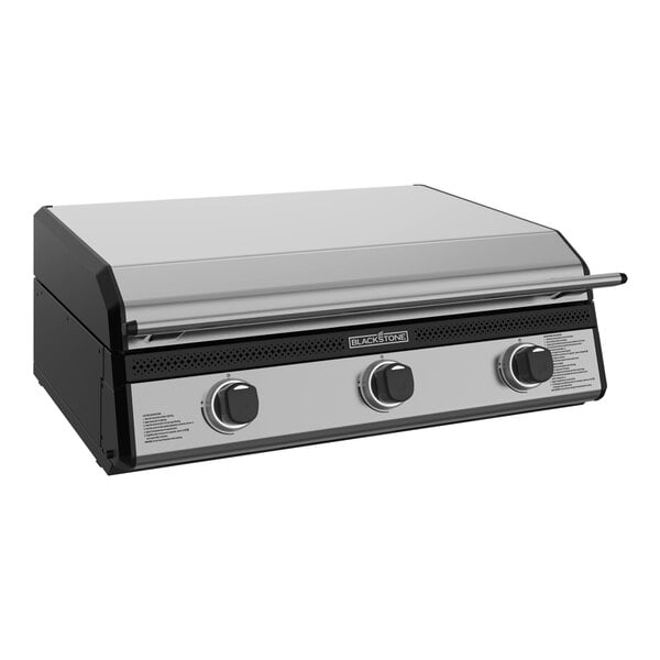 A Black and silver Blackstone outdoor kitchen griddle with a hood.