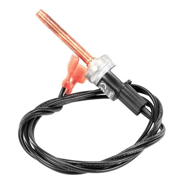 A red connector with a black and orange wire attached to a copper tube.