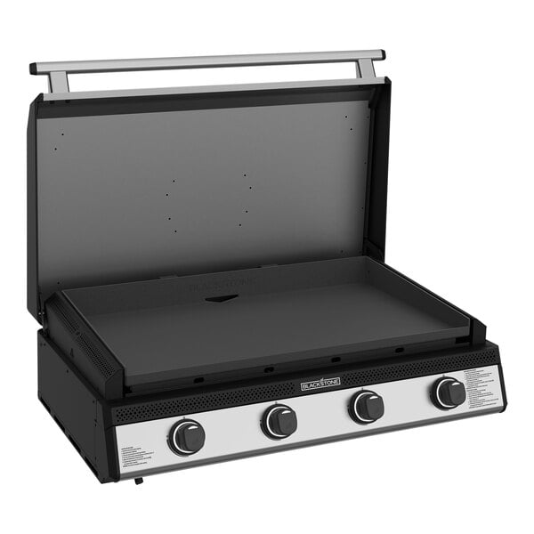 A Black and silver Blackstone outdoor kitchen griddle over three burners.