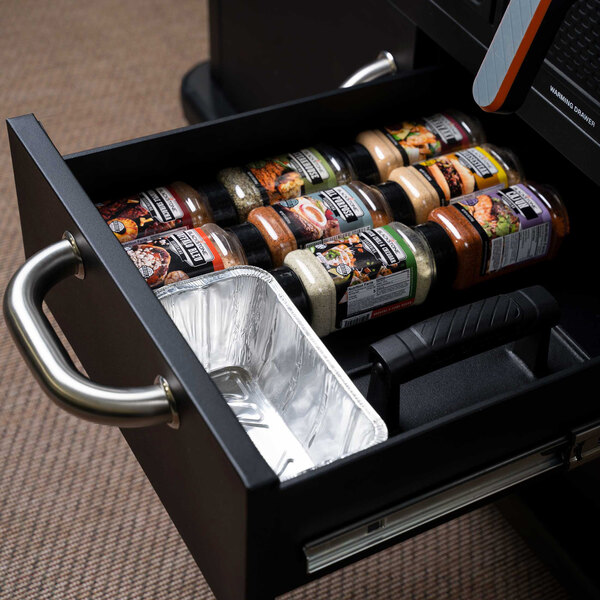 The cabinets of a Blackstone outdoor griddle filled with food and spices.