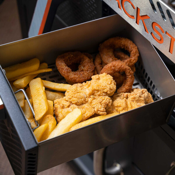 A tray of fried chicken, french fries, onion rings, and potato wedges cooked on a Blackstone outdoor griddle.