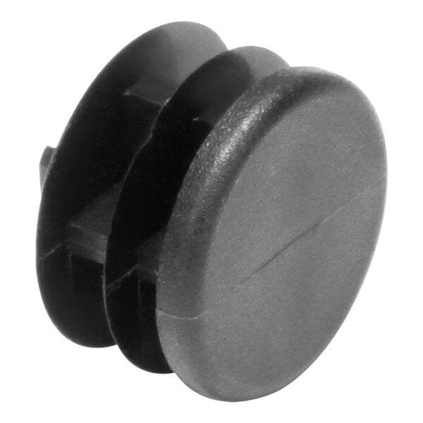 A black plastic plug with two holes on a white background.